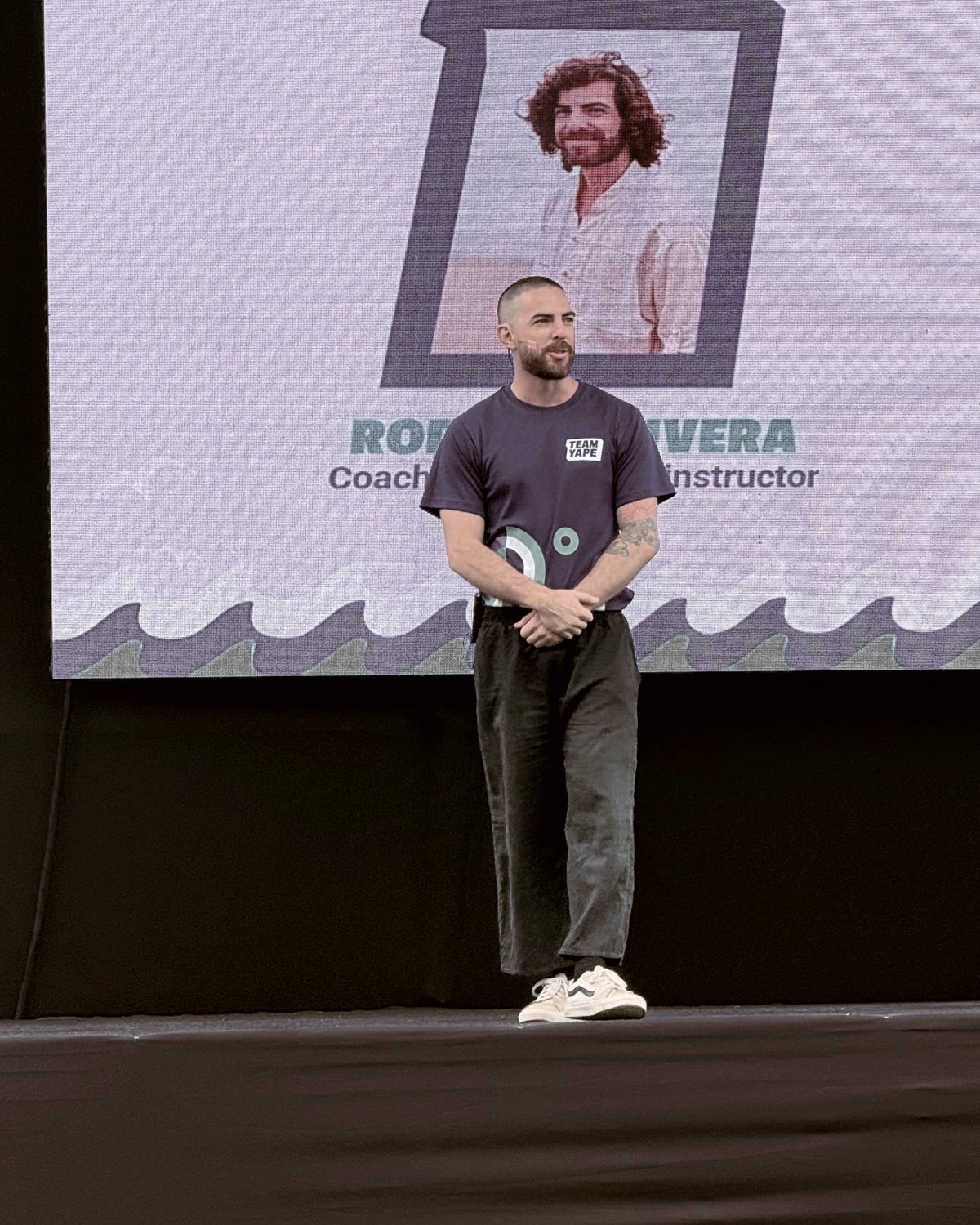 Rodri en el escenario, frente a la pantalla de la sesión de Taichi y meditación del Team Yape