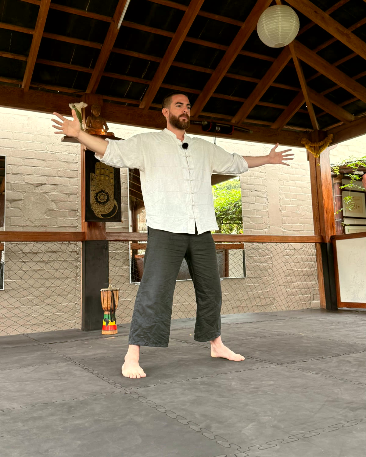 Rodri guiando una práctica con los brazos abiertos en el Dojo Buzendo